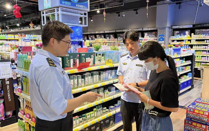 圖為該局工作人員在商場(chǎng)向群眾宣傳化妝品安全知識(shí)。