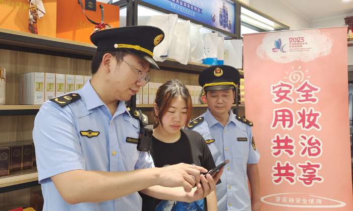圖為執(zhí)法人員指導(dǎo)經(jīng)營(yíng)戶使用“數(shù)字辨妝”一體化監(jiān)管平臺(tái)的云管理模塊。