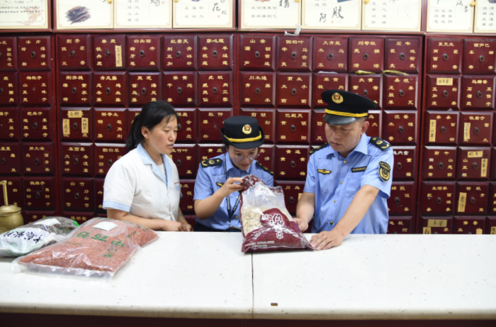 圖為該局執(zhí)法人員在一家藥品零售企業(yè)檢查在售中藥飲片質(zhì)量。