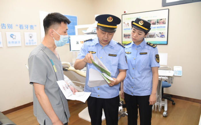 圖為該局執(zhí)法人員在一家口腔診所檢查其藥械采購索證索票情況。