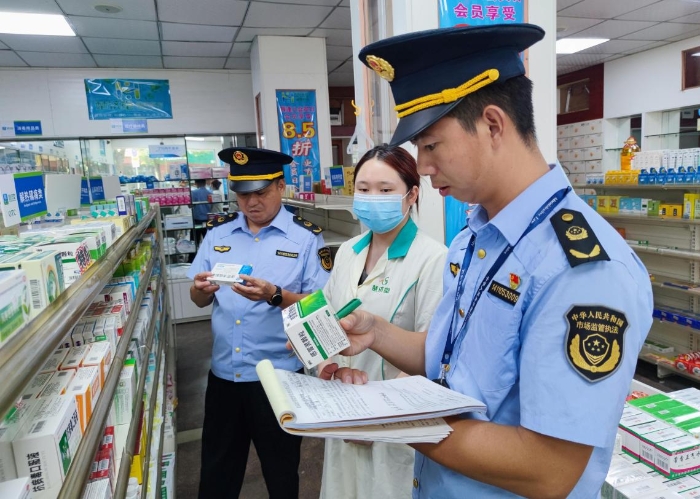 圖為執(zhí)法人員在一家藥店檢查抗病毒藥品質(zhì)量。