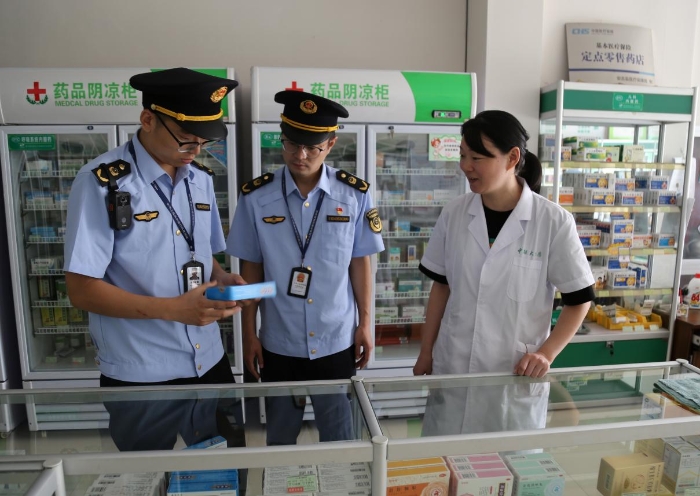 圖為執(zhí)法人員在一家藥店檢查藥品質量