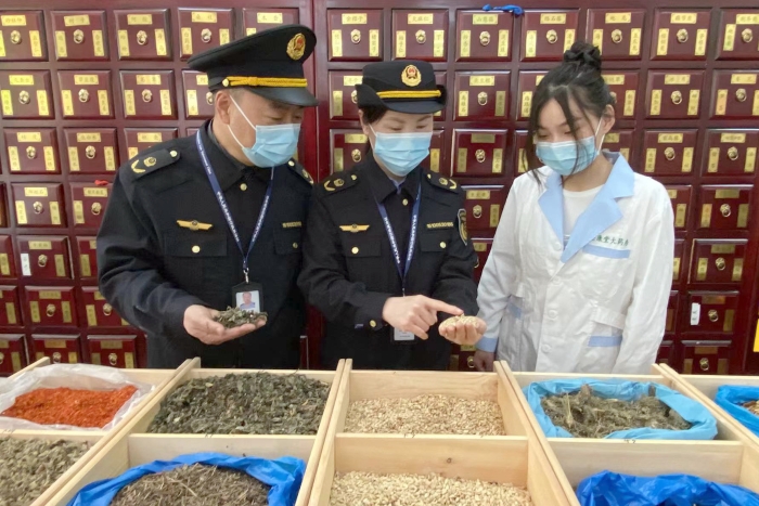 圖為執(zhí)法人員檢查中藥飲片。
