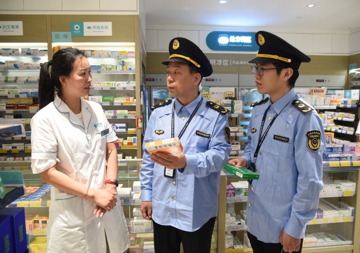 圖為執(zhí)法人員在一家藥店檢查藥品經(jīng)營情況。