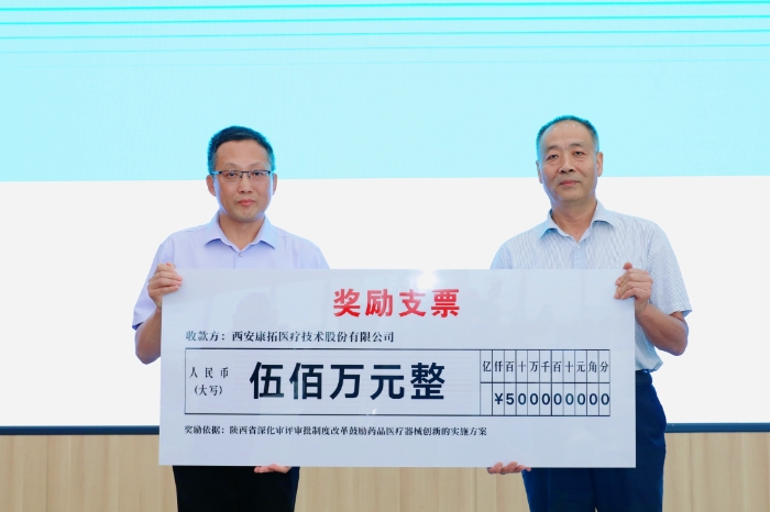圖為研討會現(xiàn)場，陜西省藥監(jiān)局二級巡視員王志宏向西安康拓醫(yī)療技術(shù)股份有限公司董事長胡立人頒發(fā)500萬元醫(yī)療器械創(chuàng)新獎勵資金。