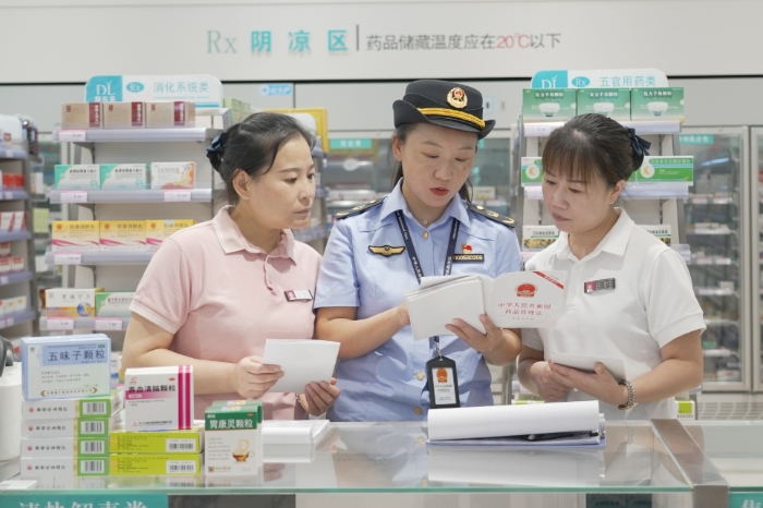 圖為8月28日，該局執(zhí)法人員向藥店經(jīng)營者解讀《藥品管理法》。（劉曉紅 董黎攝）.jpg