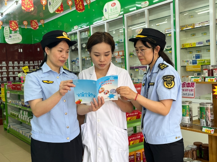 圖為8月28日，該局執(zhí)法人員會同上思縣市場監(jiān)管局在一家藥店向從業(yè)人員派發(fā)宣傳資料。（廖開軍 凌莉萍 攝）
