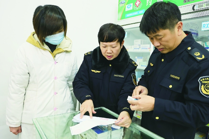 圖②為2024年1月30日，在藥品檢查專項行動中，衡陽市市場監(jiān)管局工作人員正在零售藥店查看臺賬資料。