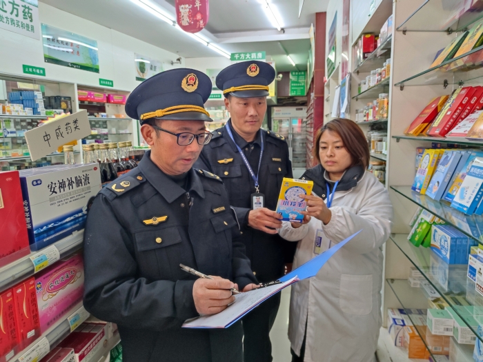 圖為近日，該局執(zhí)法人員在一家零售藥店檢查退熱貼標簽標識。（鄢國卿 攝）
